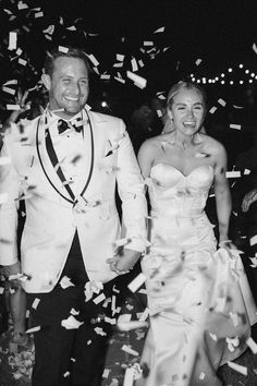 a bride and groom are walking through confetti