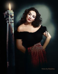 a woman is posing next to a candle