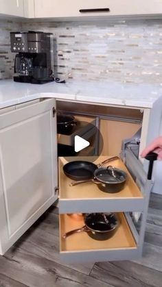 an open cabinet with pots and pans in it