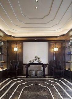 a large room with two chairs and a table in the center, on top of a marble floor