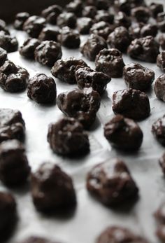 chocolate cookies are lined up on a sheet of wax paper and ready to go into the oven