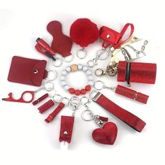 a bunch of red items are arranged in a circle on a white surface, including keychains and purses