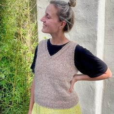 a woman standing in front of a white wall with her back to the camera and looking up