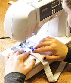 a woman using a sewing machine to sew something