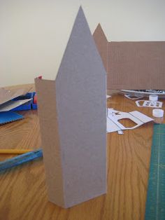 some cardboard buildings sitting on top of a wooden table