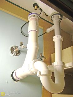 a bathroom sink with two faucets attached to the wall