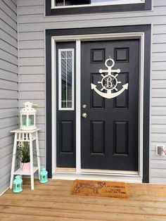 a black door with an anchor on it and a white step ladder next to it