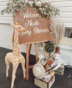 a stuffed giraffe standing next to a wooden sign