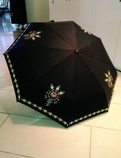 an open black umbrella on the floor in a room with tile floors and white cabinets