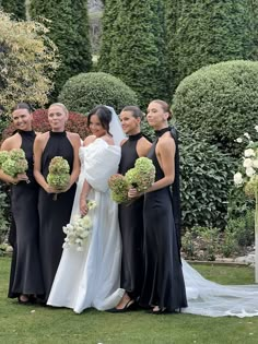 a group of women standing next to each other on top of a lush green field