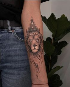 a lion with a crown on its head tattooing it's forearm and arm