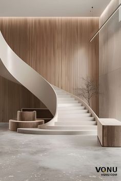 an elegant staircase in the middle of a room with wood paneling and concrete floors