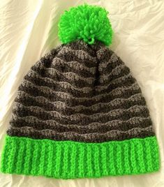 a crocheted hat with a green pom - pom on the top