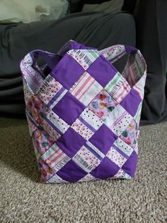 a purple and white bag sitting on the floor