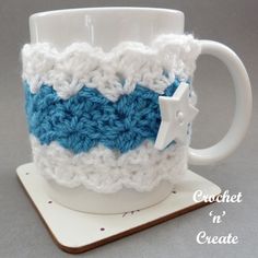 a crocheted coffee cup holder with a white and blue stripe on the bottom