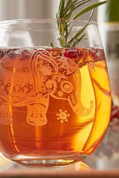 a glass filled with liquid sitting on top of a table next to a potted plant