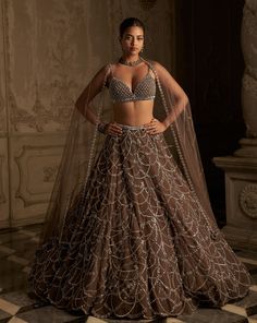 This lehenga set features crystal embroidery in chandelier inspired pattern on a coffee coloured net base. The strappy crystal embedded blouse shows ring detailing. The matching net dupatta has ring details.From Seema Gujral's Inara collection. DELIVERY TIMEPlease allow 8-12 weeks for your outfit to arrive. FABRIC DETAILSNet Professional cleaning only. Western Lehenga, Seema Gujral, Crystal Embroidery, Ghagra Choli, Party Wear Lehenga, Designer Outfits, Indian Couture, Indian Wedding Outfits, Chaniya Choli