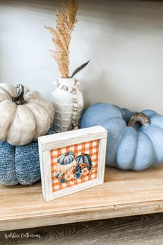 some pumpkins are sitting on a wooden shelf