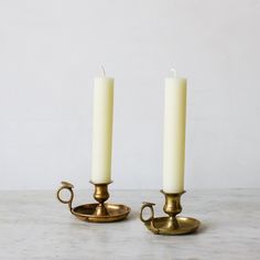 two white candles sitting on top of each other