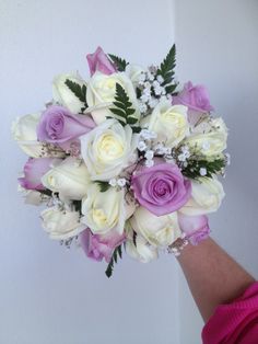 a bridal bouquet with white and purple roses