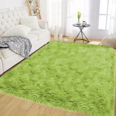 a living room with a white couch and green rug