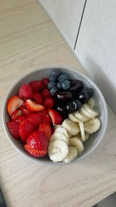 a bowl filled with fruit sitting on top of a counter