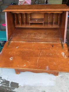 an old wooden cabinet with no doors on the top and bottom shelf is being worked on