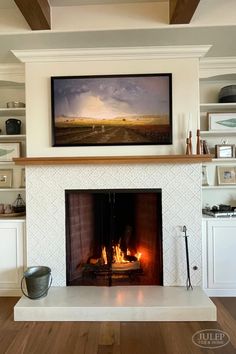 a fire place with a painting on the wall above it