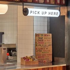 a sign that says pick up here above a counter