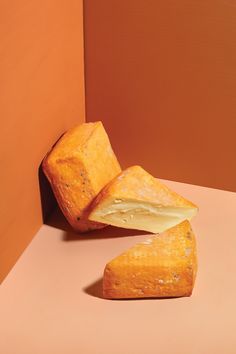 two pieces of bread sitting on top of a pink countertop next to an orange wall