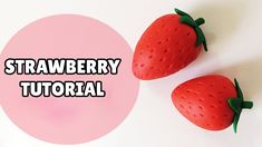 two plastic strawberries sitting next to each other on top of a pink circle with the words strawberry