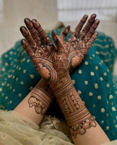 two hands that are covered in henna