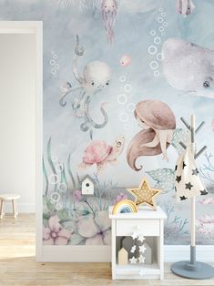 a child's room decorated in pastel colors with an underwater scene wallpaper