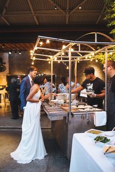 a man and woman standing in front of a buffet