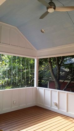 an empty room with a ceiling fan and wood flooring in front of the window