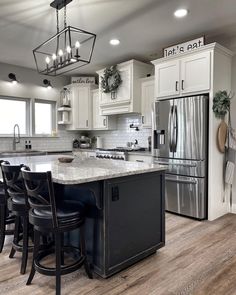 a kitchen with white cabinets and black chairs