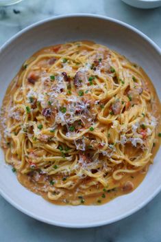 a white bowl filled with pasta covered in sauce