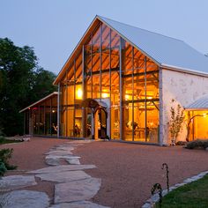 a large glass building sitting on top of a lush green field