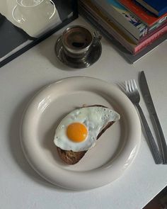 an egg is sitting on top of toast with a fork and knife next to it