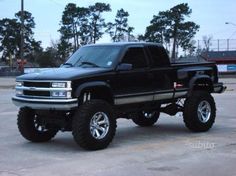 a large black truck parked in a parking lot