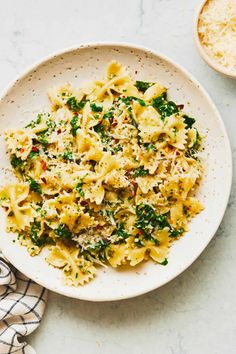 a white bowl filled with pasta and spinach