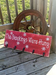 a wooden sign that says the stocking were hung on a porch with snowflakes