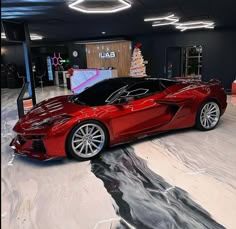 a red sports car is parked in a garage with christmas decorations on the wall behind it