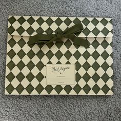 a green and white checkered envelope with a bow