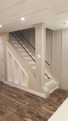 an empty room with stairs leading up to the second floor and another door on the other side