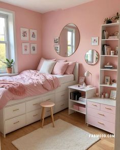 a bedroom with pink walls, white furniture and a large round mirror on the wall