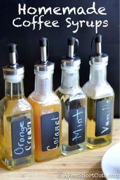 four bottles with labels on them are lined up