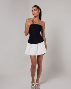 Introducing the Black Strapless Colorblock Flare Mini Dress, a chic and versatile piece that combines modern style with a playful silhouette. Featuring a sleek black strapless bodice that highlights the neckline and shoulders, the dress contrasts with a flared white skirt for a flattering colorblock design. The fitted top hugs the body, while the flared skirt adds movement and dimension, making it perfect for both casual and semi-formal occasions. Ideal for summer outings or evening events, this Chic Off-shoulder Bandage Dress For Summer, Chic Stretch Strapless Dress, Chic Strapless Stretch Mini Dress, Chic Strapless Bandage Dress For Summer, Chic Stretch Strapless Cocktail Dress, Chic Black Strapless Mini Dress, Chic Black Strapless Tube Top, Chic Off-shoulder Tube Top For Cocktail, Chic Off-shoulder Cocktail Tube Top