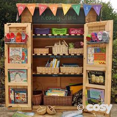 an outdoor book stand with books and baskets on it's sides, next to a sign that says reading shed