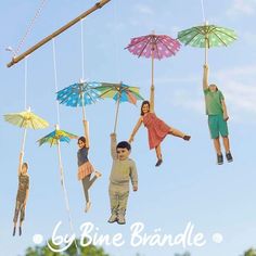 four people hanging upside down with umbrellas in the air and one person holding up an umbrella